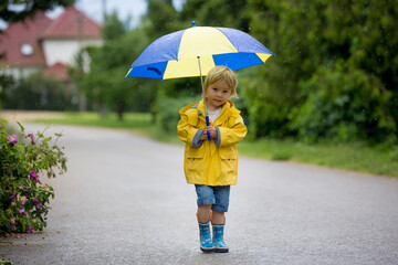 Mother and toddler child, boy, playing in the rain