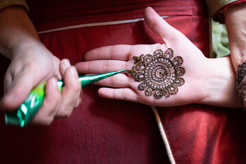 Top down video of a woman copying the mehndi henna tattoo from one hand to the other in preparation...