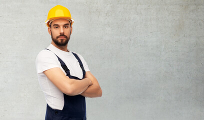 profession, construction and building concept - male worker or builder in yellow helmet and overall...