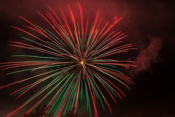 Brilliant red and green fireworks against the backdrop of the night sky, Vittorio Veneto, Italy