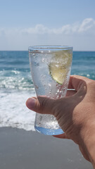 A glass of sparkling water on the beach 