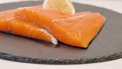 raw salmon fillet on black board