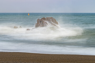海岸の大きい岩と夕日