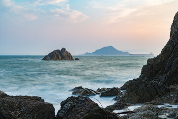 Fototapeta na wymiar 海岸の大きい岩と夕日
