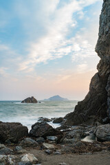 海岸の大きい岩と夕日