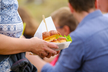 Crop person with delicious sandwich in crowd