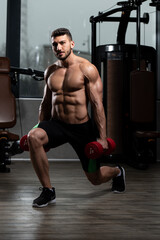 Fototapeta na wymiar Man With Dumbbells Exercising Quadriceps And Glutes