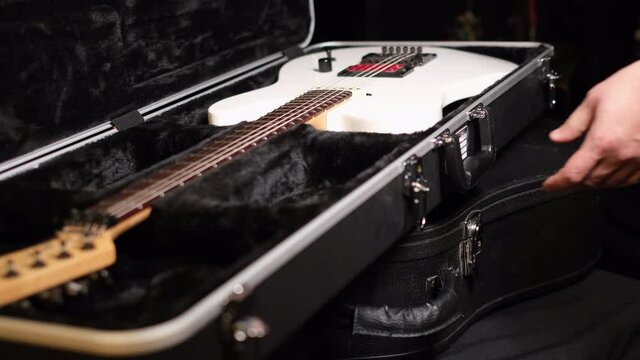 Close frame of male hands opening guitar case  