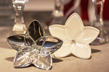 A gilded and white flower on a festively laid table is a home decor item.