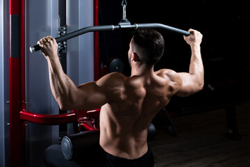 Fototapeta na wymiar Bodybuilder Exercising Back In Gym