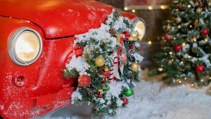 Christmas decorations on a red classic car outdoors. Santa claus car
