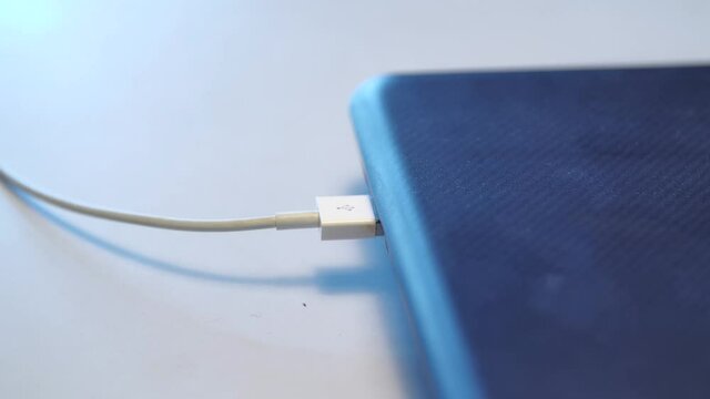 Man inserting usb cable into laptop. Media. Close up of male hand сonnecting the device cable with a computer isolated on white background.
