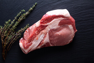 Food concept raw pieces  of  pork shoulder  on black slate stone board with copy space