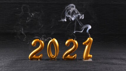 extinguished golden New Year 2021 candles on black background. modern concept.