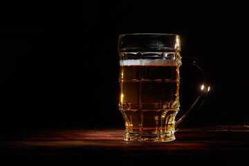 Large glass mug of beer on dark background 