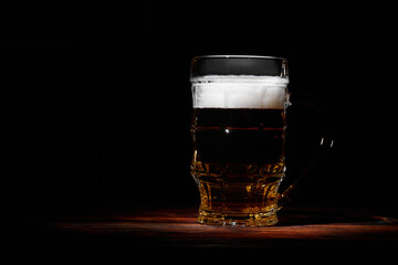 Large glass mug of beer on dark background 