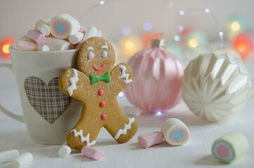 Cup with marshmallows and gingerbread man on a blurred background.
