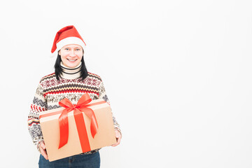 Woman courier in santa hat and christmas sweater holding gift on light background
