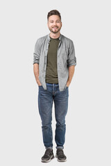 Fototapeta premium Full length portrait of handsome smiling young man, laughing joyful cheerful men isolated studio shot