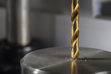 metal drill bit make holes in steel billet on industrial drilling machine. Metal work industry....