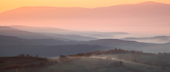 panorama of mountains in the fog at sunrise. autumn season