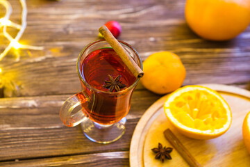 Mulled wine with spices on wooden background
