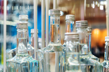 Glass bottles with vodka at the distillery. Close-up of alcohol without labels