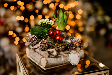 beautiful composition of plants and pine cones and wooden sticks decorated with christmas balls