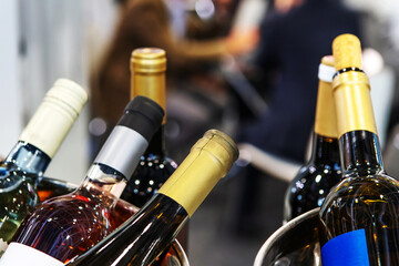 Wine in glass bottles is randomly located. Trade in alcohol at the bar. Close-up