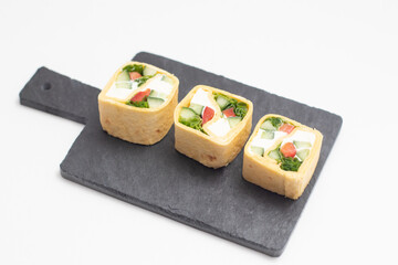 Set of Tortilla roll with vegetables served on a black slate board