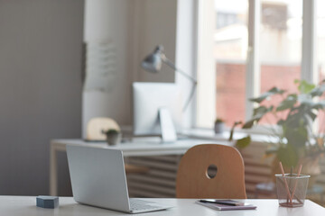 Image of laptop for online work on the desk at empty modern office