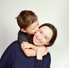 Son hugs mom on white background