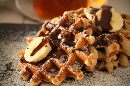 Belgian banana waffles in powdered sugar are on the table	