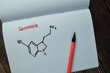 Chemical molecular Formule Hormone Serotonin write on a book isolated on Wooden Table.