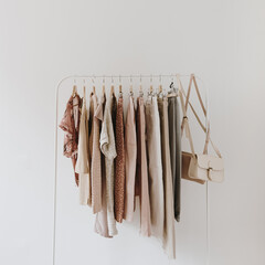 Women's fashion bright pastel clothes on hanger on white background. Minimalist fashion blog...