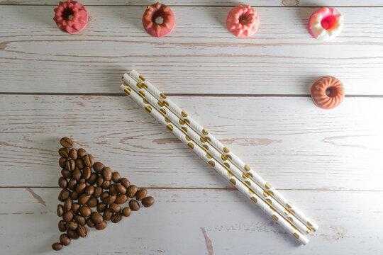 flatlay concept abstract showing coffee beans, straws, candies candles on a white wooden background perfect for a cafe menu or restaurant with copyspace