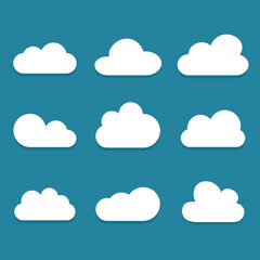 Fototapeta premium White cartoon clouds set isolated on blue background. Collection of different cartoon clouds for background template, wallpaper and sky design. Cartoon clouds vector. Sky illustration