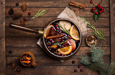 Christmas mulled red wine with the addition of spices and citrus fruits in a small vintage copper...