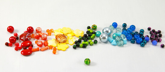 Beads of all colors of the rainbow on a white background