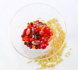 Red beads in a glass standing on gold beads