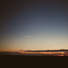 Beautiful sky and a plane flying by at sunset