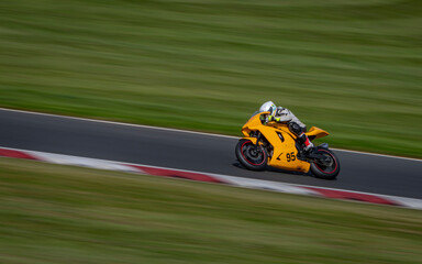 A panning shot of a racing bike cornering on a track.