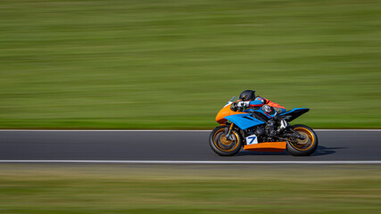 Fototapeta premium A panning shot of a racing bike cornering on a track.