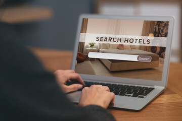 Woman searching hotel using laptop at table, closeup. Booking online service