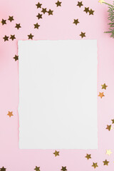 Christmas card mockup template with fir twigs and golden stars and festive decoration on a pink pastel background. Design element for CHristmas and New Year congratulation