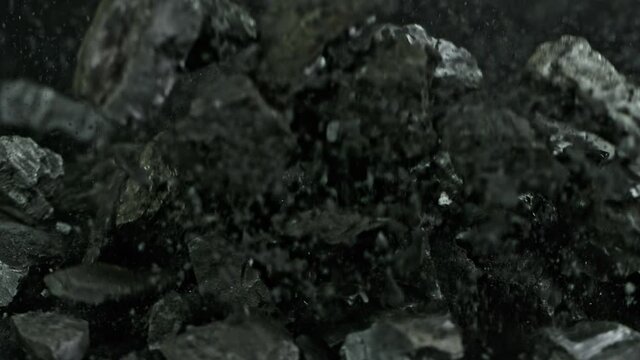 Super Slow Motion Shot of Coal and Black Powder Falling on Black Background at 1000 fps.