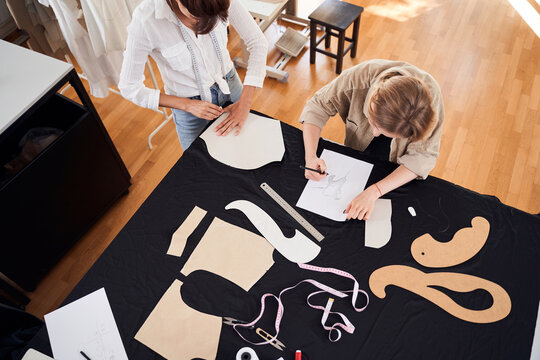 Designers making patterns on the black fabric