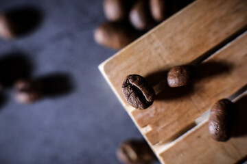 Coffee beans on a wooden pallet and dark grey background. Coffee break. Morning espresso. 