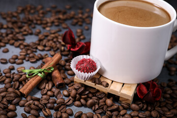 White cup full of coffee beans close up against the dark grey background. Coffee mug. Morning espresso.	