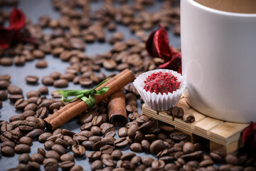 White cup full of coffee beans close up against the dark grey background. Coffee mug. Morning espresso.	